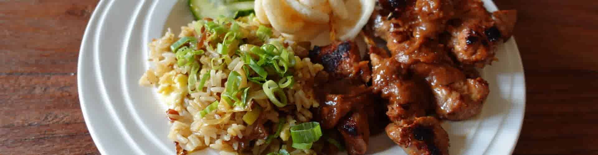 Varkenshaassaté met pindasaus, gebakken jasmijnrijst en komkommer in het zuur